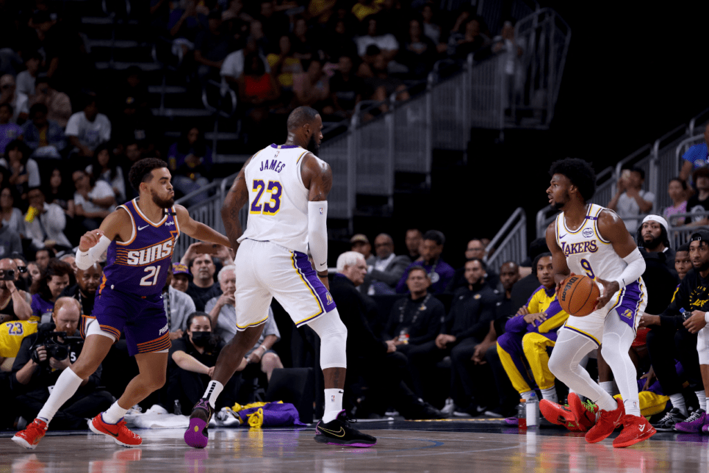 LeBron James (cen.) e Bronny (dir.) atuaram juntos pela primeira vez no último domngo