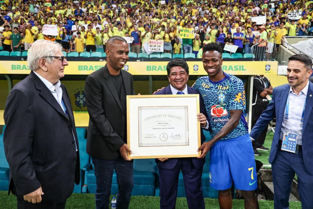 Vini Jr. com a placa da ancestralidade ao lado do presidente da CBF